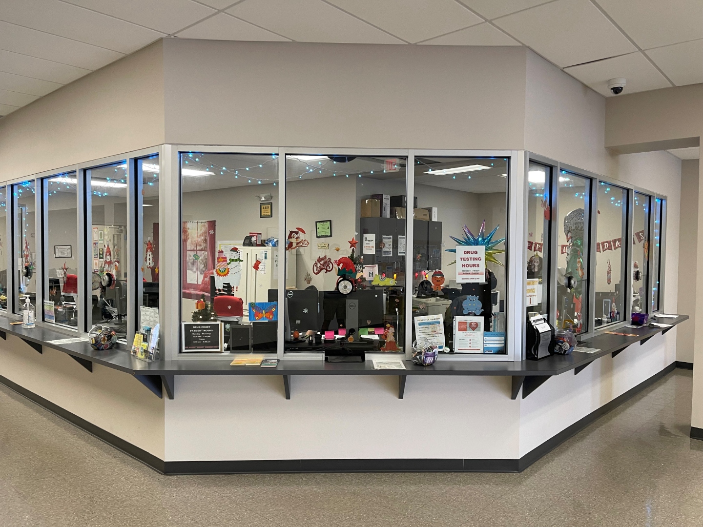 Long custom-cut transaction-window run at a Lauderdale Lakes government services facility, BallistiMAX glass-clad polycarbonate retained in the existing aluminum frame.