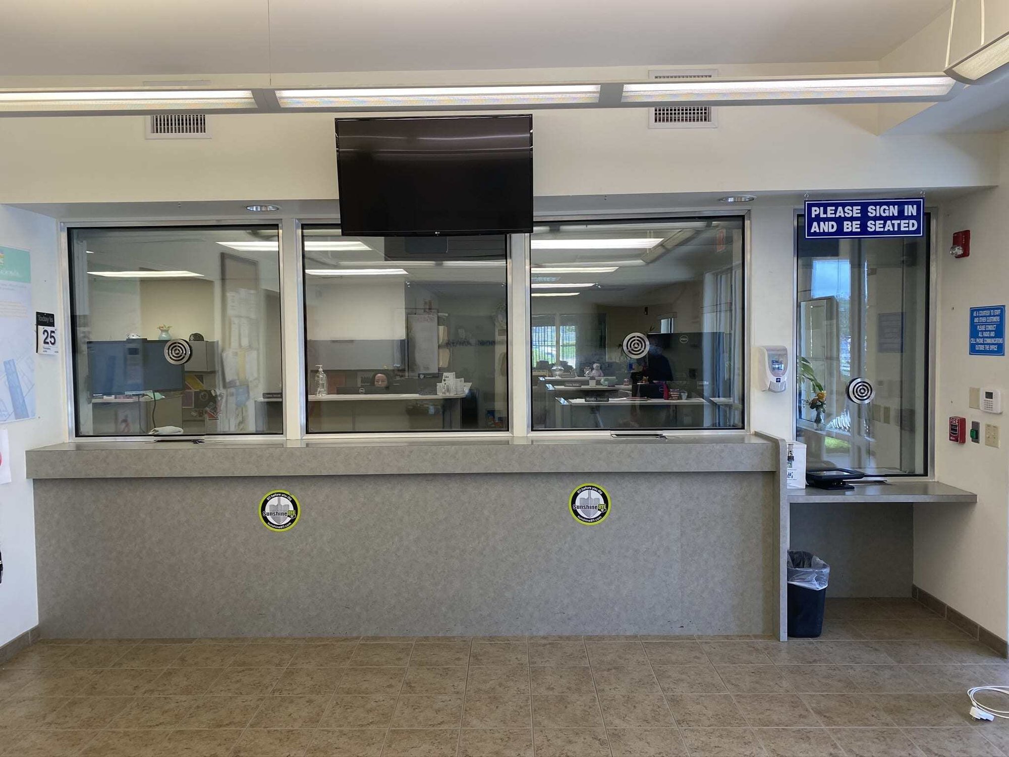 Commercial reception lobby with BallistiMAX installed, stickers marking stopped rounds.